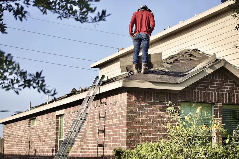 Professional roofer working on a residential roof in Romola